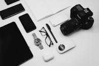 Black Camera and Wireless Gadgets on a Flat Surface