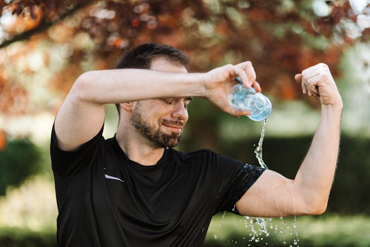 A Man Pouring Water On His Arm 