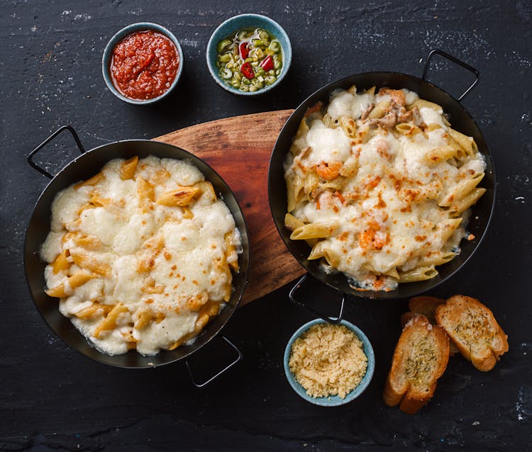 Delicious Macaroni With Cheese Served On Table With Toasted Bread And Sauce Bowls