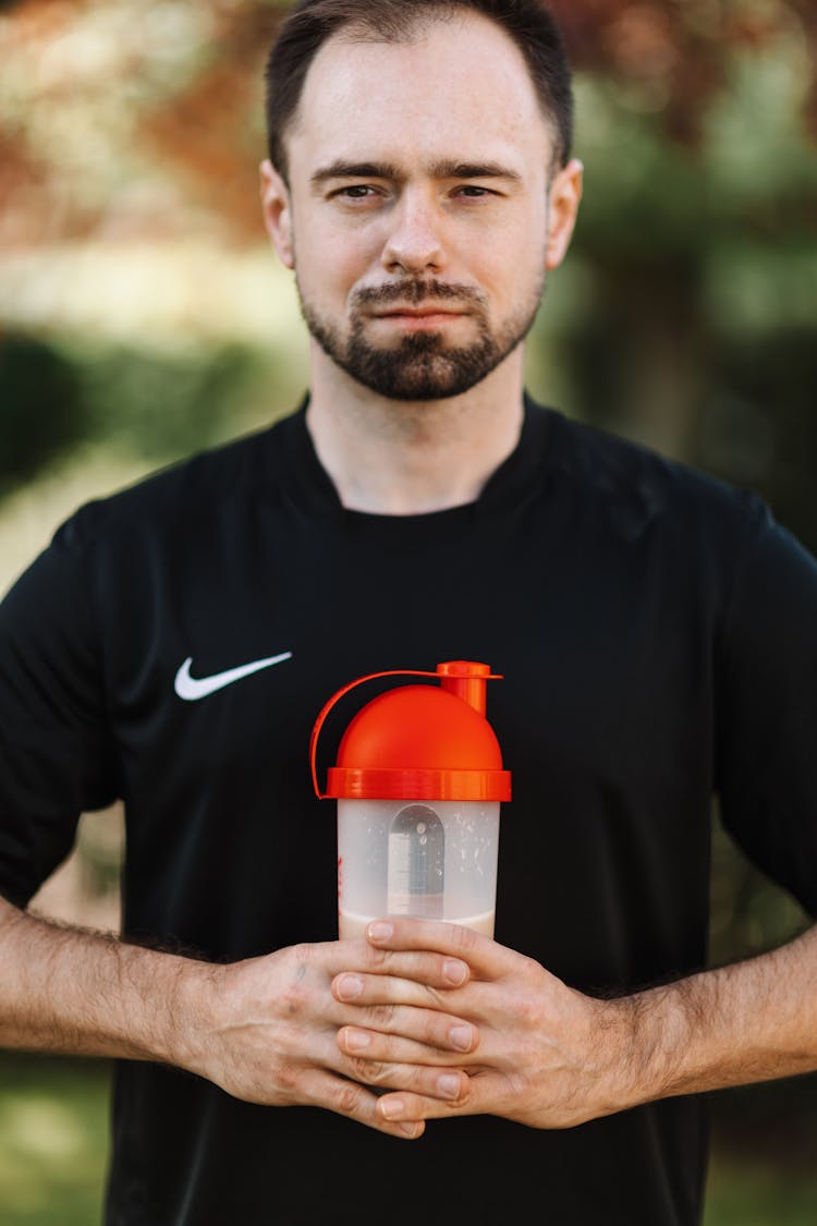 Man In Black Nike Crew Neck T-shirt Holding A Plastic Tumbler