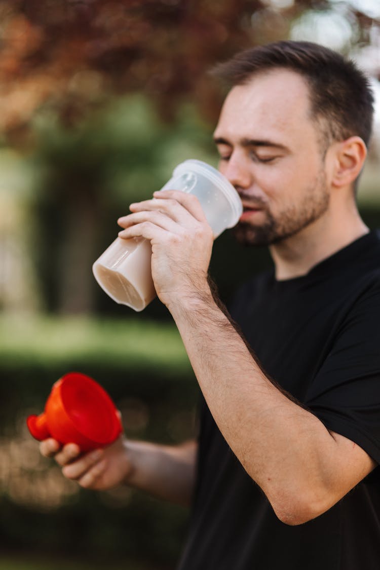 Man In Black Crew Neck T-shirt Drinking From A Plastic Tumbler