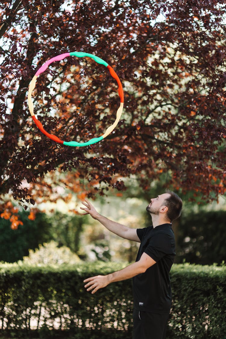 A Man Throwing A Hula Hoop In The Air 