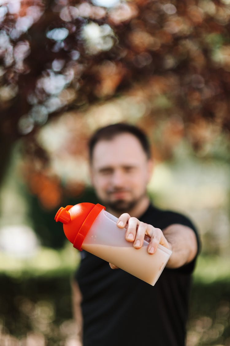 A Man Holding A Plastic Tumbler