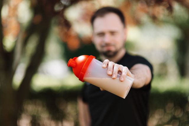 Nutrition sportive : un homme tient un shaker de protéines