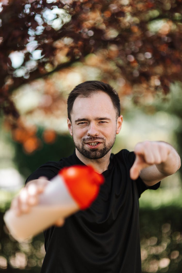 A Man Holding A Plastic Tumbler Pointing Finger