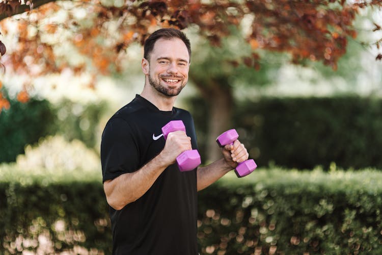 Smiling Man In Black Crew Neck T-shirt Exercising Outdoors