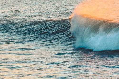 Free High angle of powerful big foamy wave of rippling ocean rolling at sunset Stock Photo