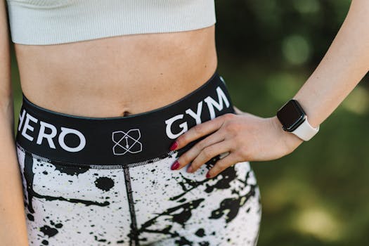 Close-up of a woman's hand on her activewear showcasing a smartwatch, emphasizing fitness.