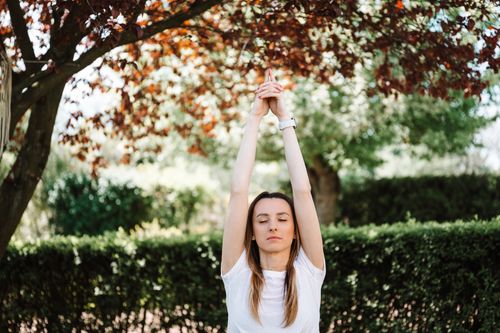 Free A woman meditating with closed eyes, practicing yoga under a tree in a tranquil outdoor setting. Stock Photo