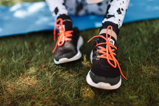草地上，一双带有红色鞋带的运动鞋特写，非常适合运动和户外主题