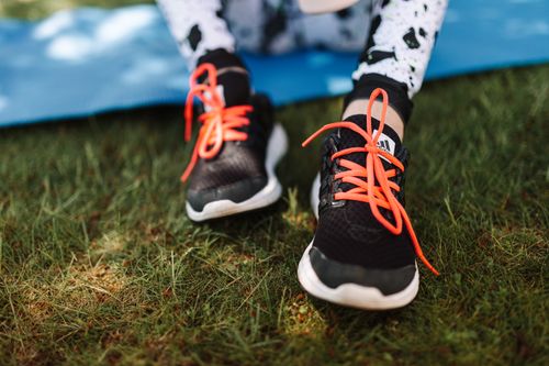 Free Close-up of sneakers with red laces on grassy field, ideal for sports and outdoor themes. Stock Photo