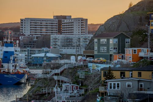 Free Vibrant coastal town at sunset with colorful houses and harbor view. Stock Photo