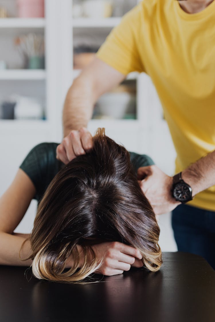 Person Grabbing Woman's Shoulders