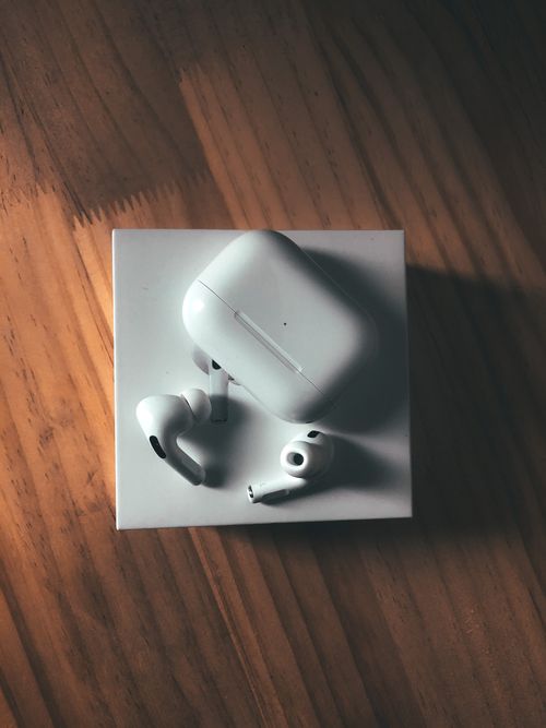 Free Top view of modern true wireless earphones with plastic charging box places on wooden table Stock Photo