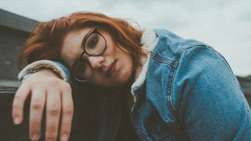 A Woman in Denim Jacket Resting Her Head