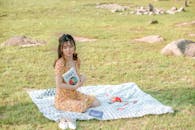 Concentrated Asian female student doing homework on lawn