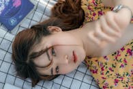 Alluring young Asian female lying on blanket near book