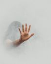 Unrecognizable female outstretching hand and trying to get out of thick fume during fire