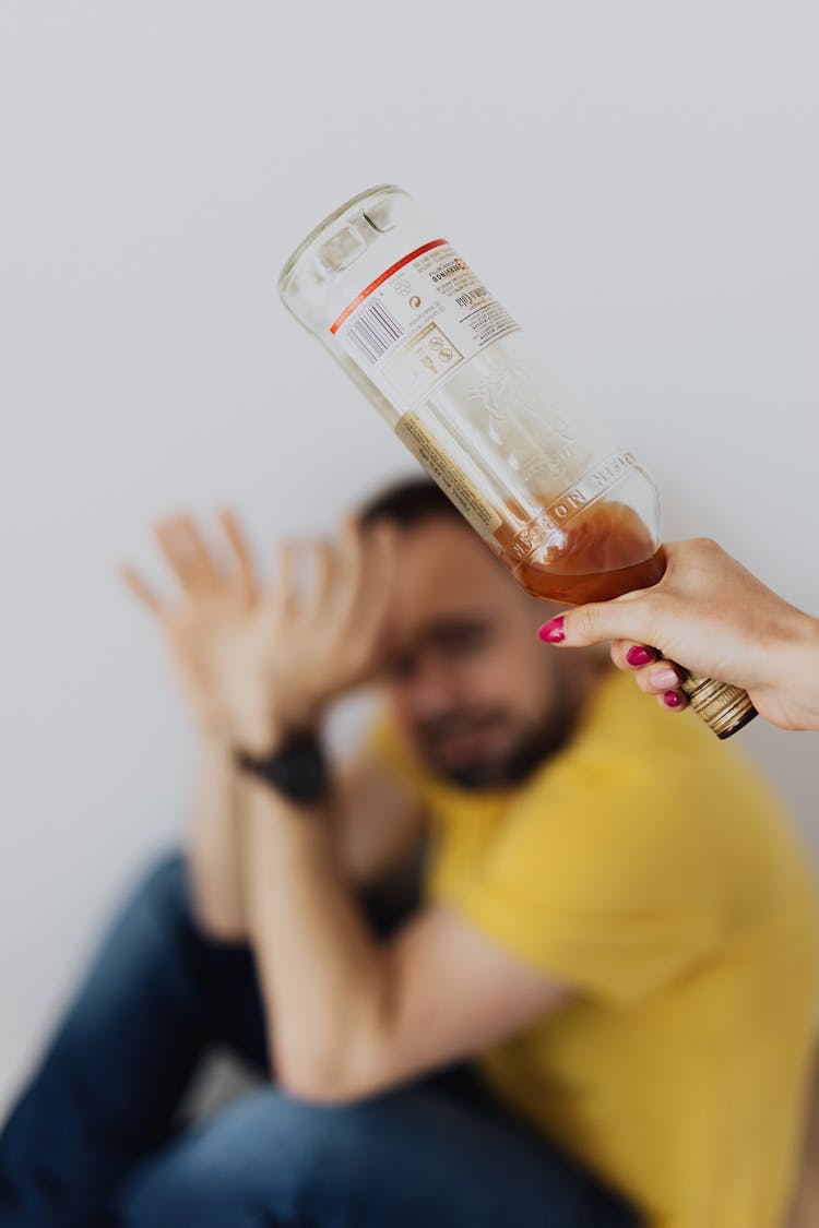 Hand Of A Woman Holding Bottle About To Hit A Man