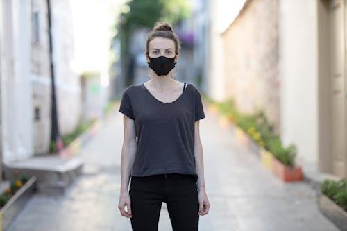Free Woman in Black Shirt and White Face Mask Standing Stock Photo