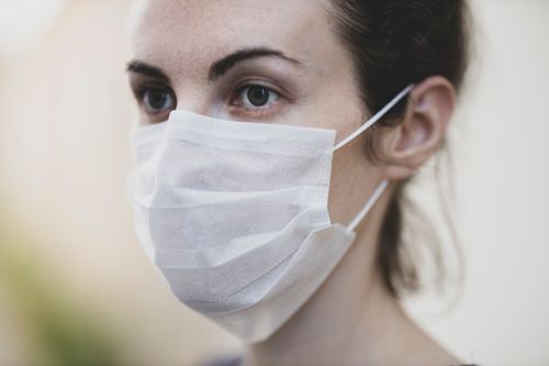 Free Close-up of a woman wearing a protective face mask for health safety. Stock Photo
