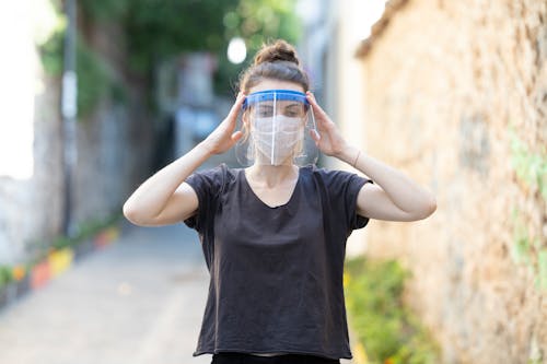 Woman Wearing White Face Mask and a Face Shield