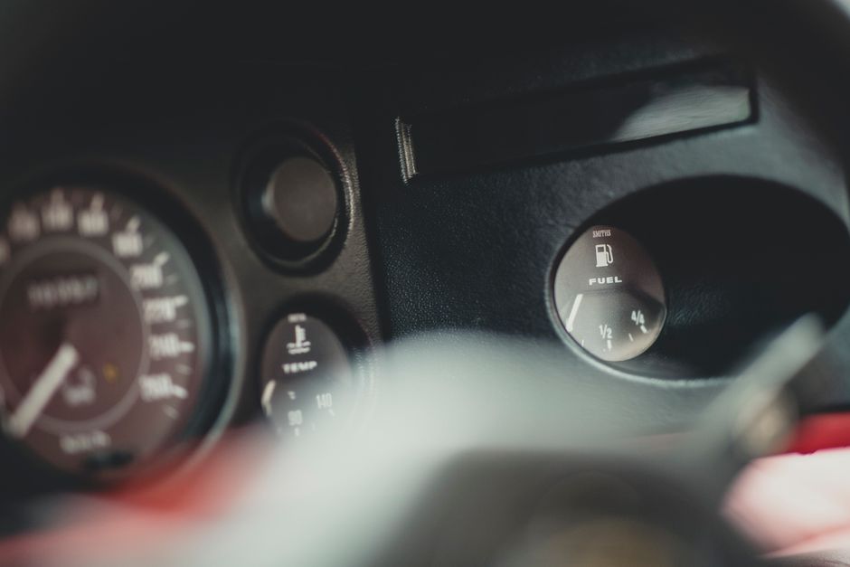 Vozač čita uputstvo za upotrebu automobila pored kontrolne table