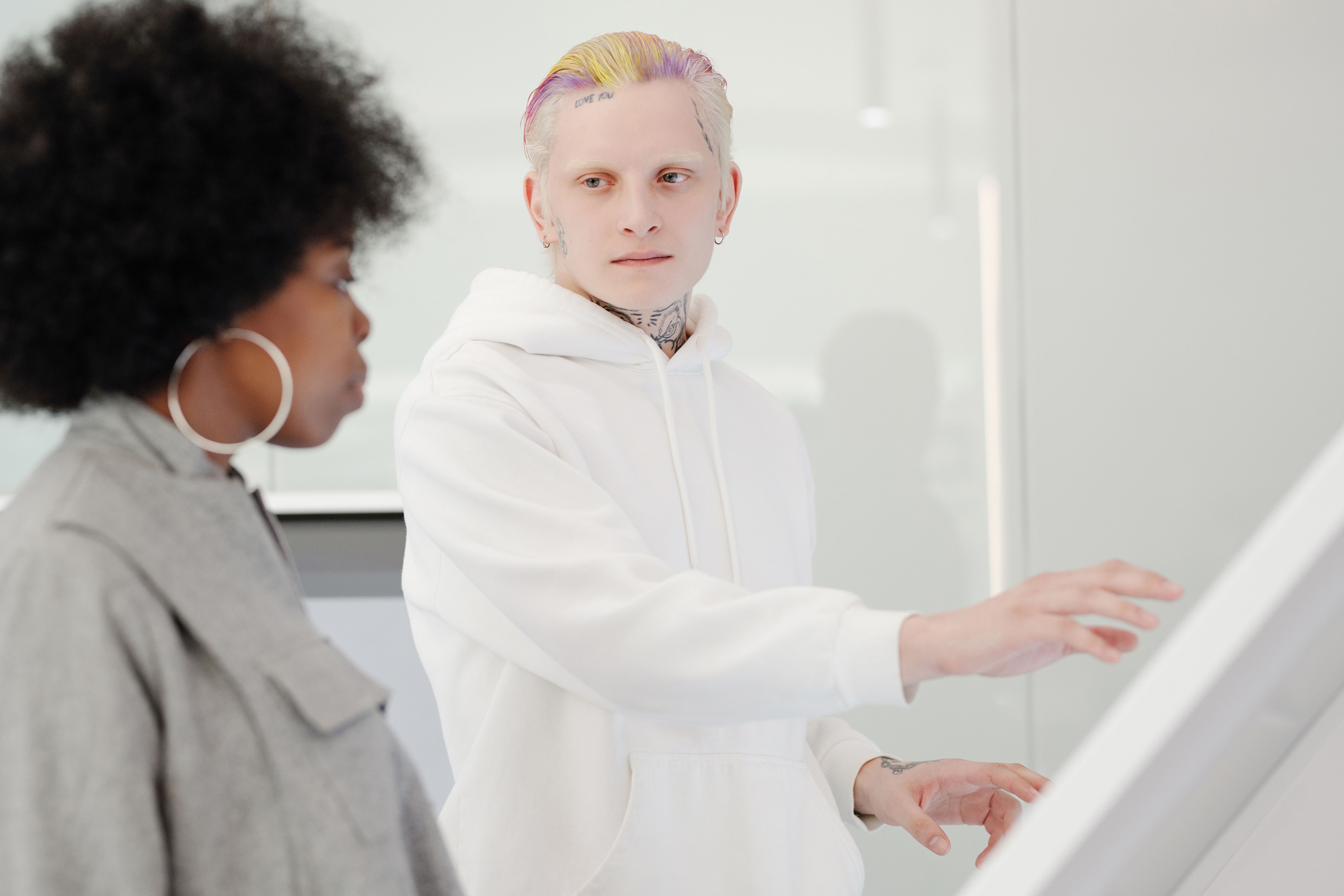 A diverse group of professionals (designer, musician, writer) collaborating around a screen showing AI interfaces