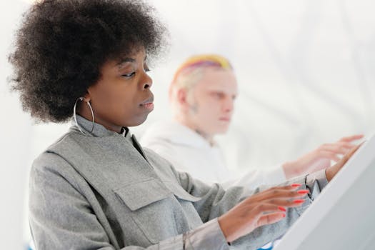 Two adults using touchscreens, showcasing modern tech in a bright environment.