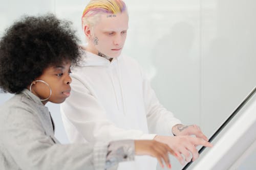 A Man with Colorful Hair Using a Touchscreen Device