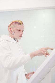 在现代环境中，有纹身和彩色头发的人使用触摸屏