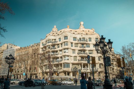 View of Casa Milà, a landmark in Barcelona, showcasing unique architecture and vibrant city life.