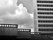 低角度视角下，一栋带有玻璃窗的现代建筑映衬着多云的天空