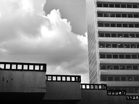 低角度视角下，一栋带有玻璃窗的现代建筑映衬着多云的天空