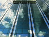 这座玻璃摩天大楼令人印象深刻，其反射窗捕捉着天空与云层