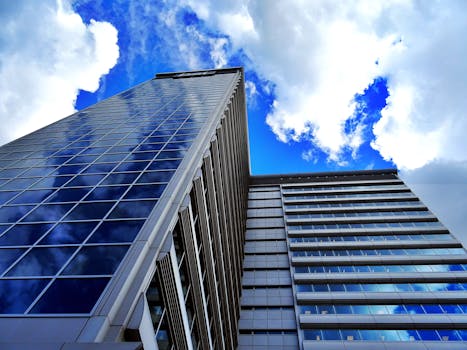 现代摩天大楼的低角度视图映照着蓝天和云彩，展现了城市建筑风貌