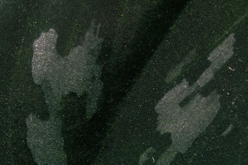 Free Detailed close-up of a textured black leather surface with wet spots and reflections. Stock Photo