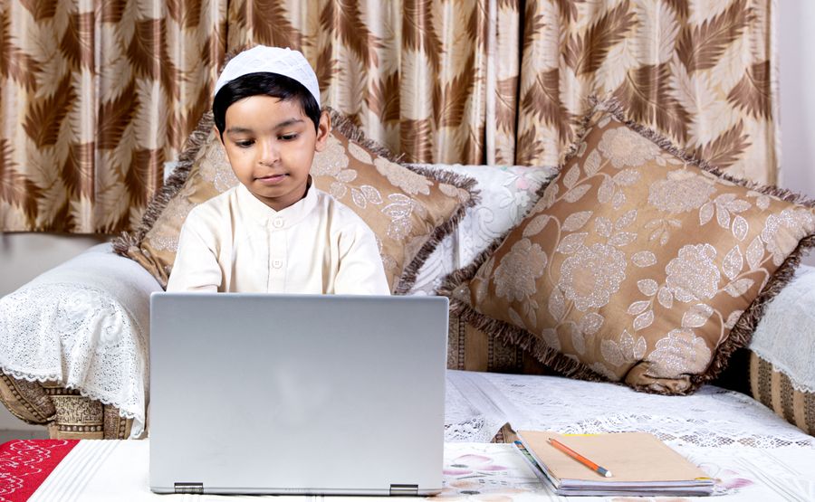 Young Muslim boy learning online from home