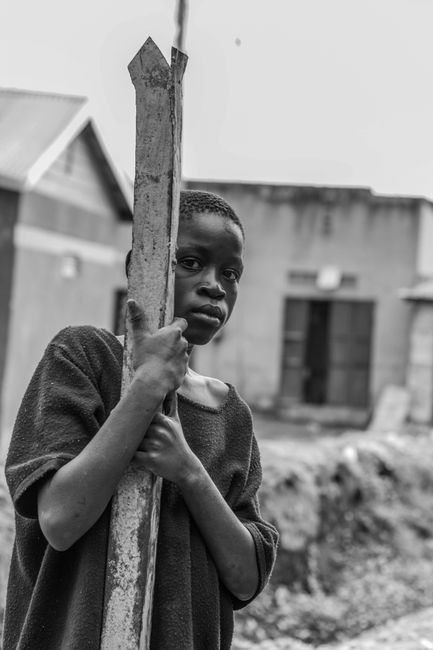 Black and white African American boy with metal detail on street with shabby buildings