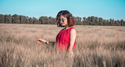 Young stylish woman in field at daytime