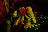 一群成年人在光线昏暗的室内使用笔记本电脑进行合作