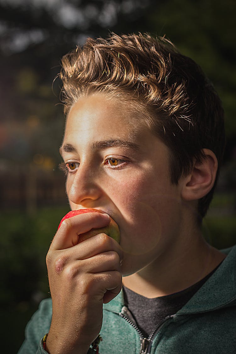 Close Up Of A Young Man Eating An Apple