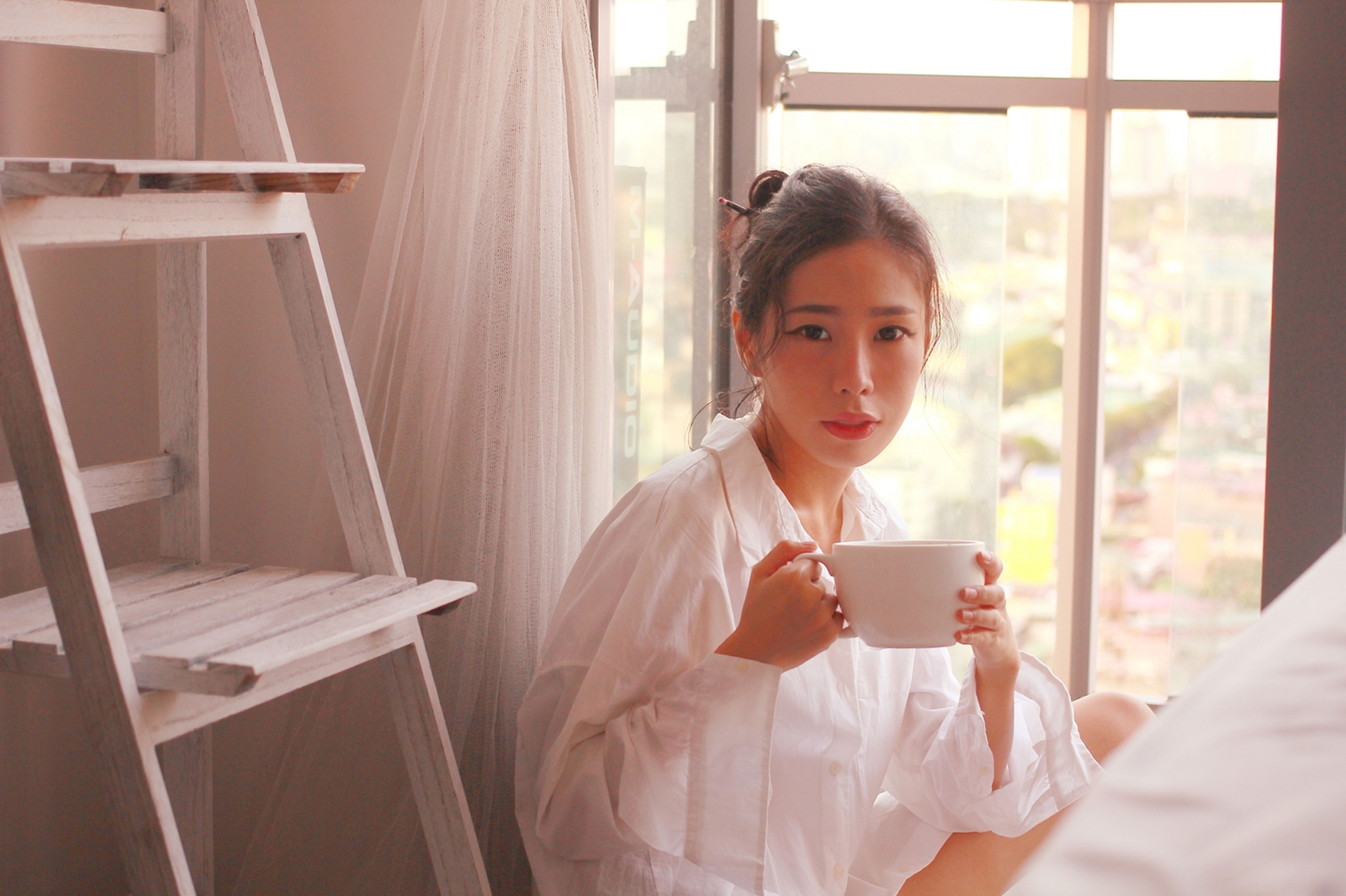 Woman in White Long Sleeves Holding a White Ceramic Mug · Free Stock Photo