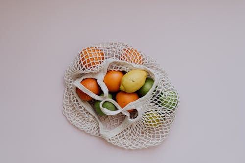 Free Various Citrus Fruit in Bag Against White Background Stock Photo