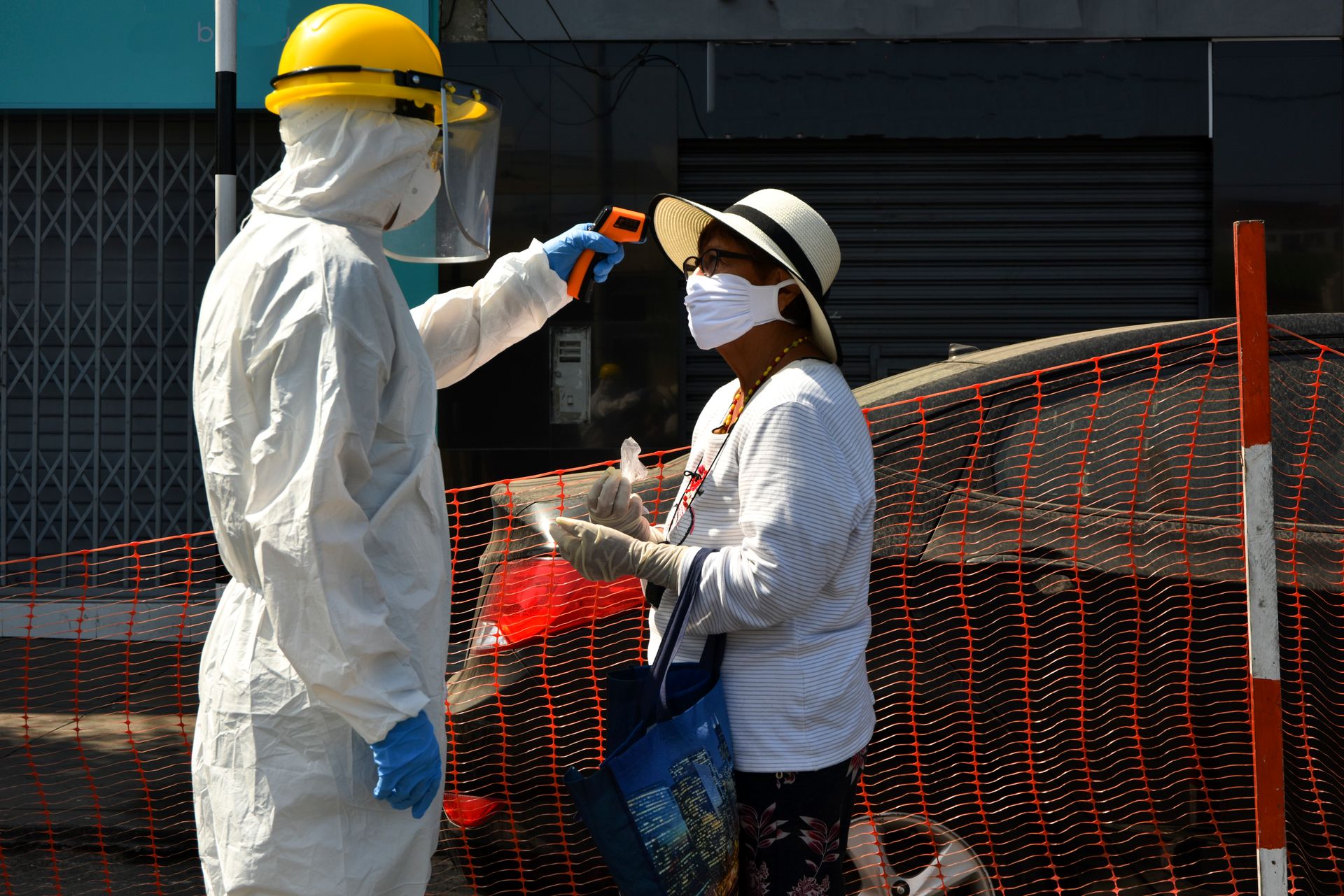 Healthcare worker checks woman's temperature during COVID-19 pandemic in Lima, Peru.