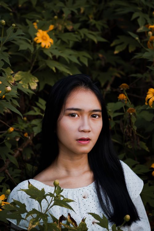 Free Serious young Asian female with black hair looking at camera in park in daylight Stock Photo