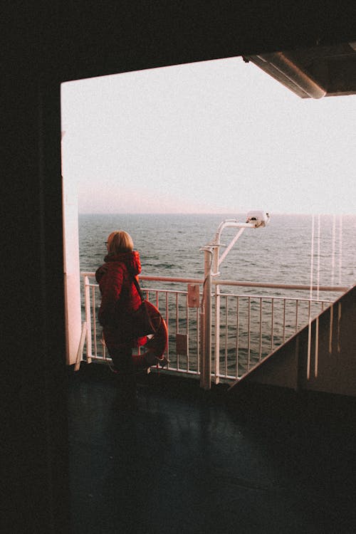 A Woman in a Red Puffer Jacket in a Ship