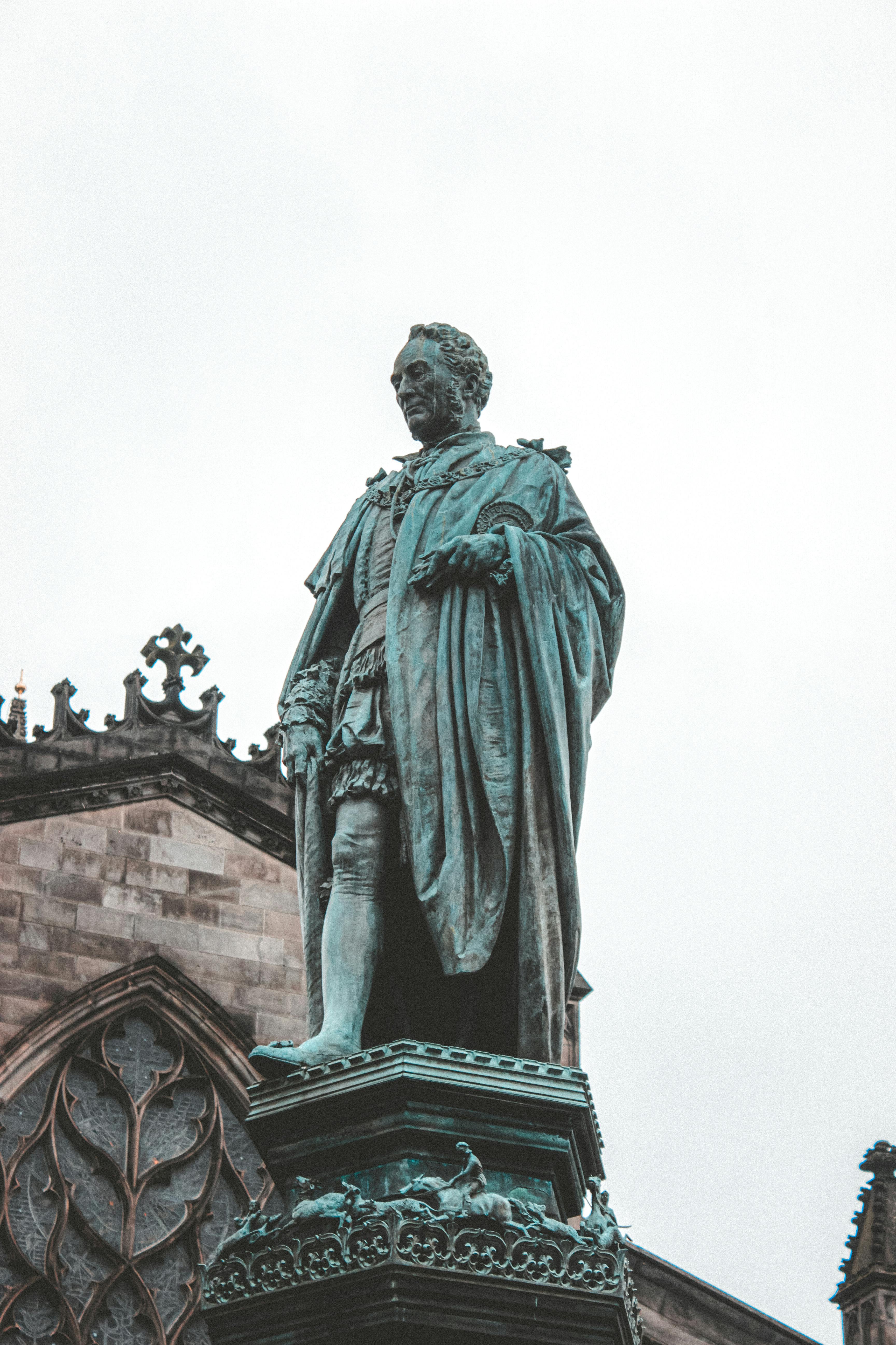 statue of adult man in cloak