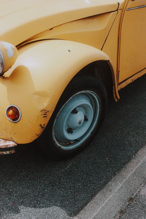 Free Small red headlight on colorful yellow fender above black rubber wheel of old automobile Stock Photo