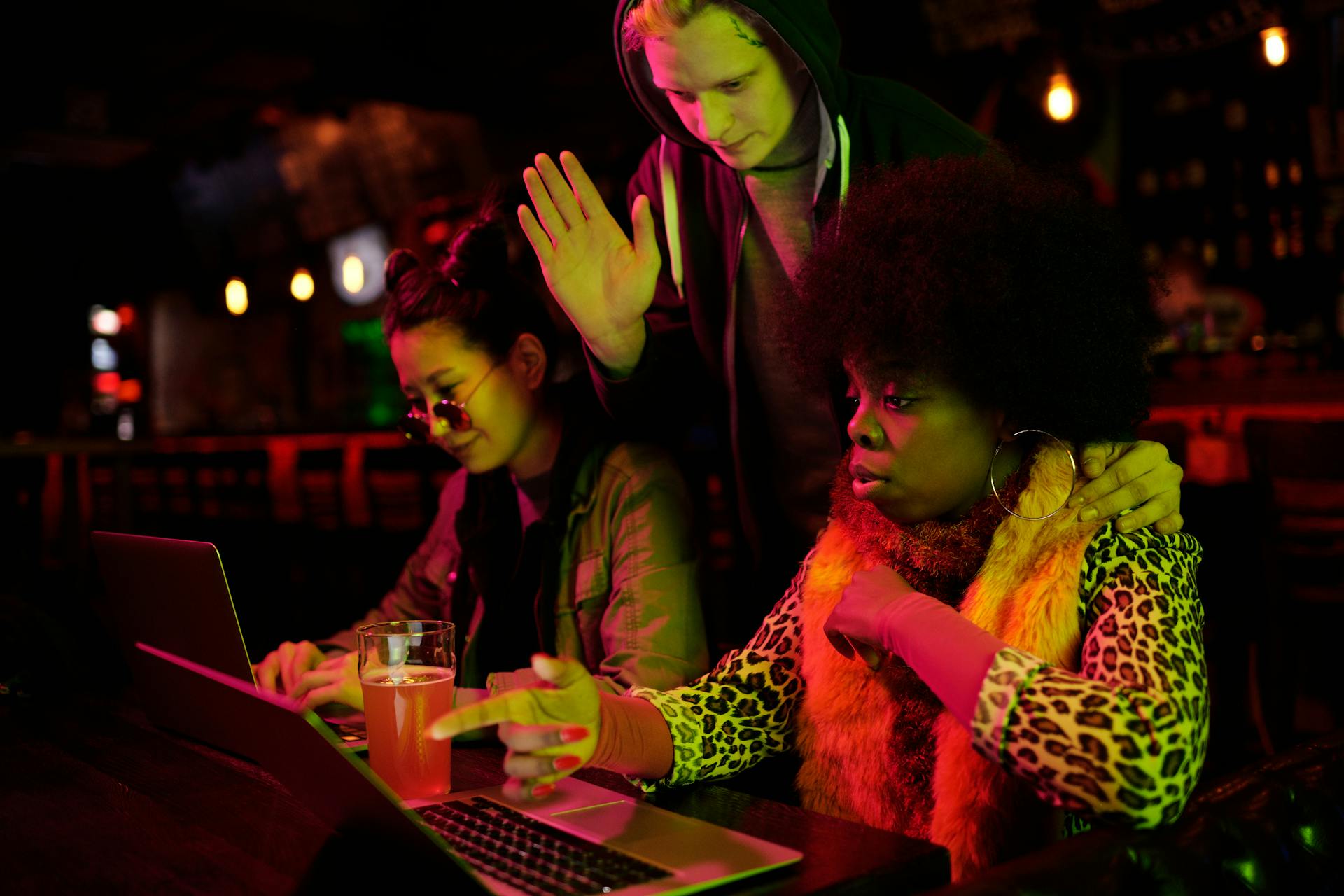 Diverse group of adults working together with laptops in a trendy café setting, fostering collaboration and creativity.